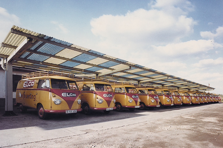 Historische ELCO Servicefahrzeuge mit Firmenlogo in einer Reihe auf dem Betriebsgelände.